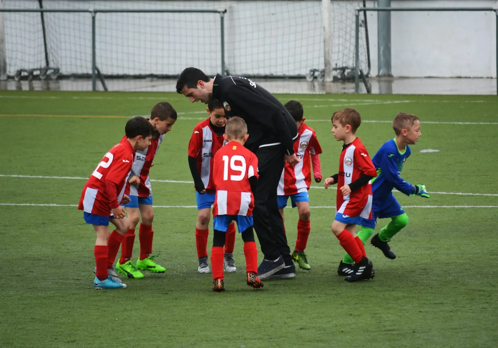 Kinderen in gele shirts rennen achter de bal aan
